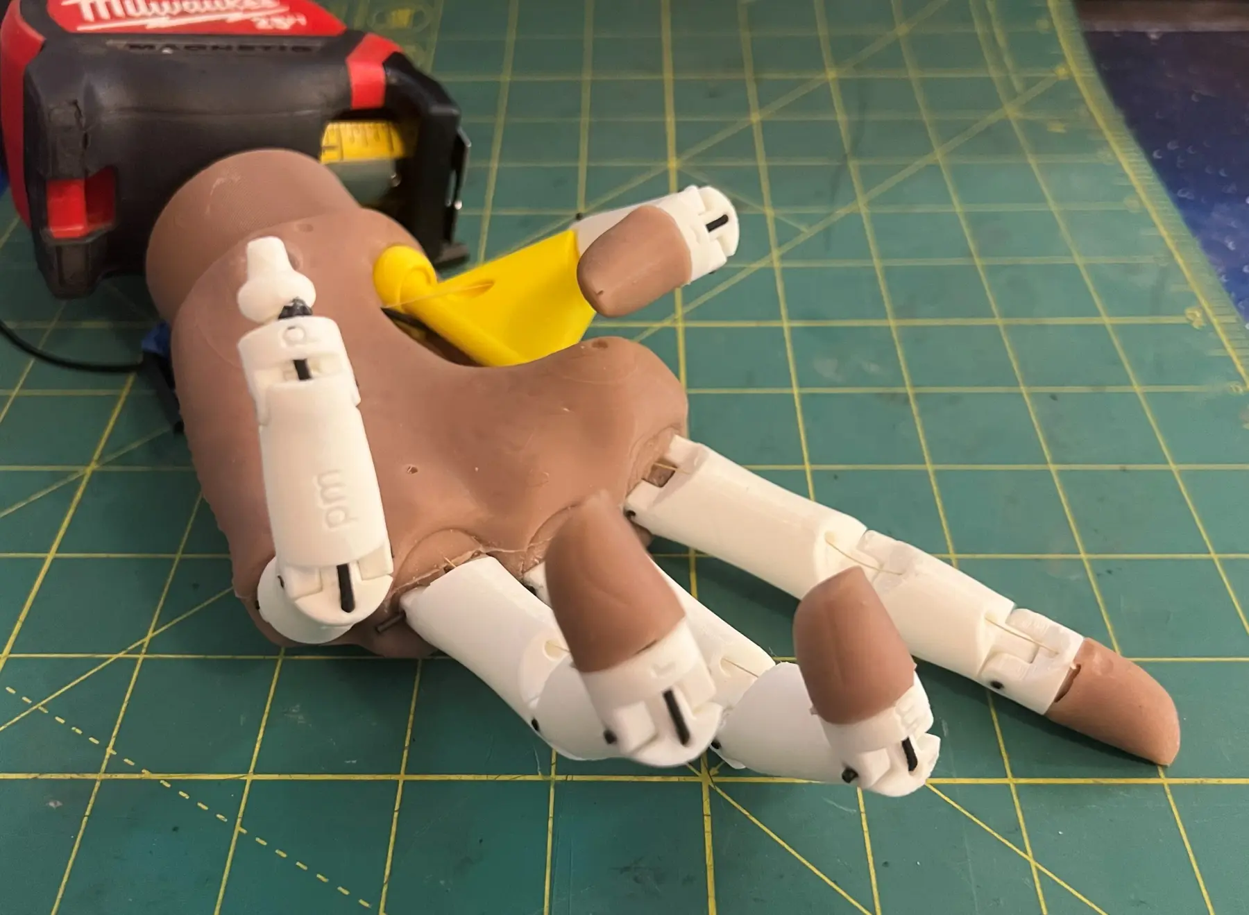 Prototype articulated prosthetic hand on a workbench